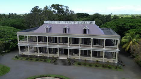 Luxury-mansion-surrounded-by-tropical-plants,-establishing-shot