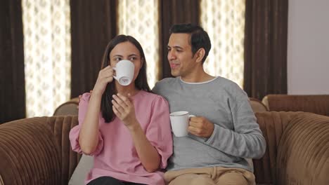 happy indian couple drinking tea and talking to each other