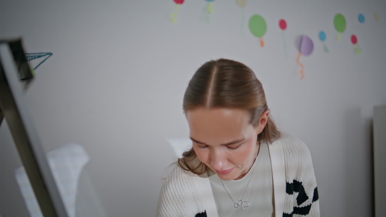 Cheerful tutor holding felt-tip-pen writing whiteboard elementary school closeup