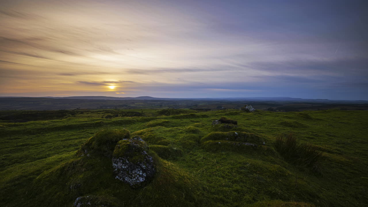 timelapse de movimiento panorámico del paisaje rural durante la puesta de sol y la hora azul en el campo de tierra de hierba en el condado de sligo en irlanda