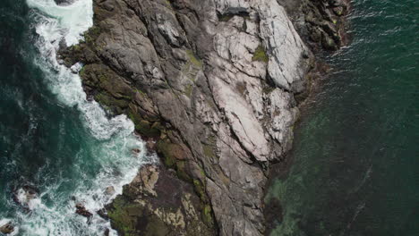 vista aérea de una roca en las aguas blancas espumosas de la ola en la bahía de naragansett