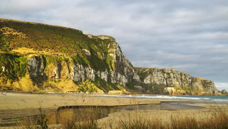 asentamiento de purākaunui en otago, en la isla sur de nueva zelanda vista panorámica de la playa del océano con río de agua de corriente natural y formación de acantilados pintorescos