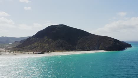 Drone-Tira-Hacia-Atrás-Sobre-El-Agua-Playa-Tecolote,-Baja,-México