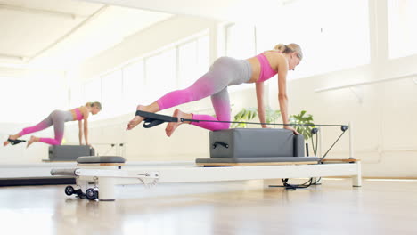 caucasian woman practicing pilates on reformer machine