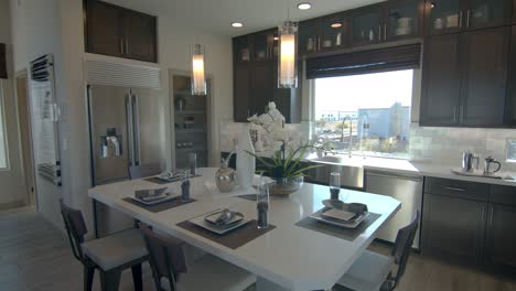 a simple modern interior design fully furnished residential house with table set-up, flower arrangement, and a hanging transparent lighting tubes in las vegas nevada - wide shot
