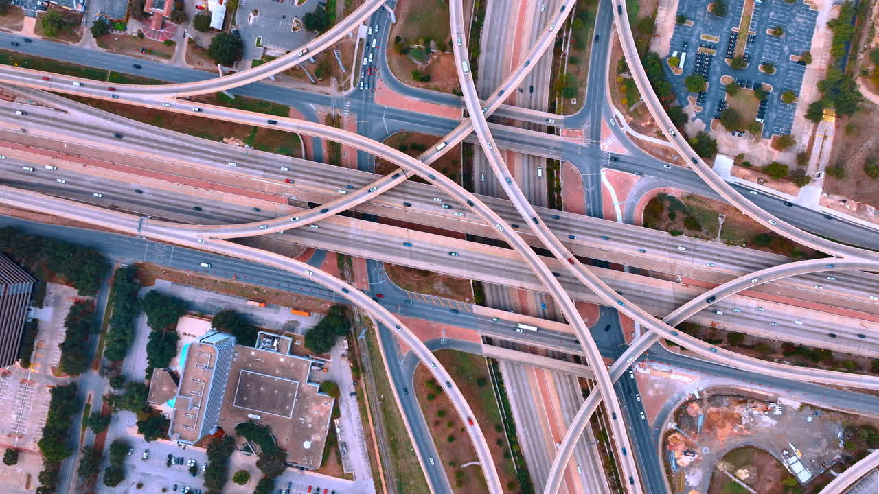 Transport moves non-stop by the intertwining highways and trestles in the multi-level interchange. Commuting in the metropolis. Top view