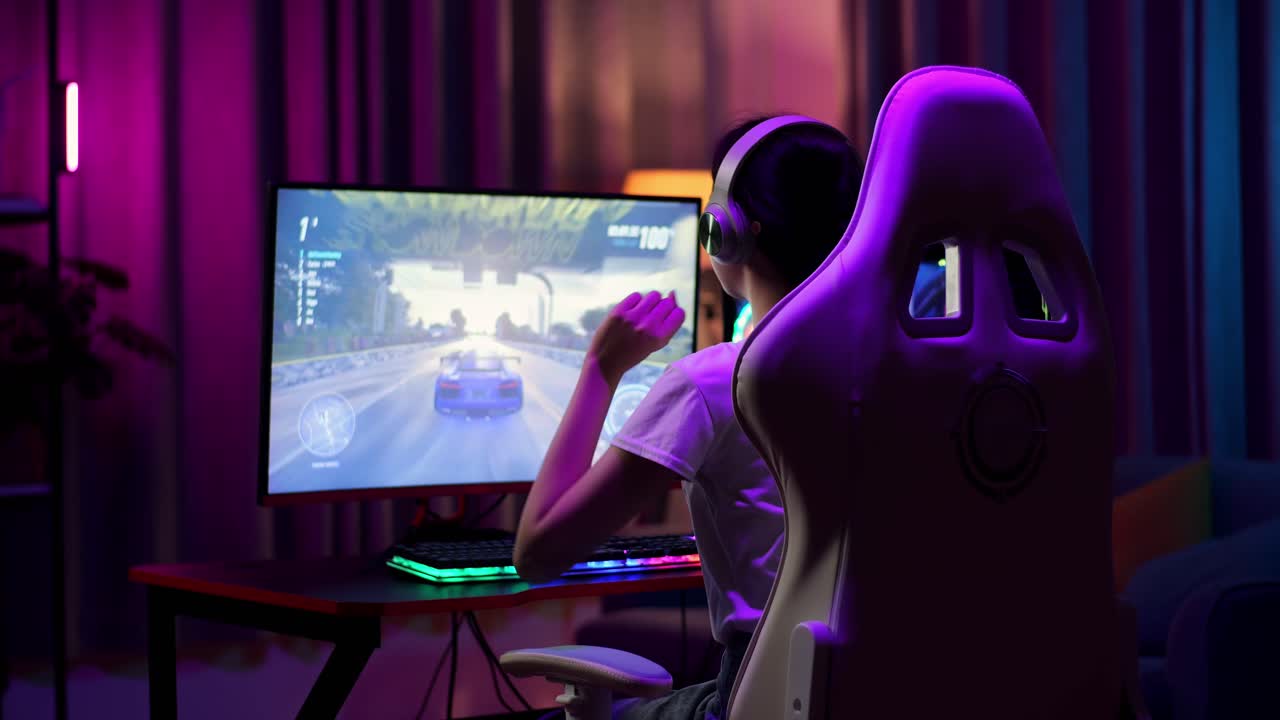 gamer adolescente asiática entusiasmada comemora a vitória enquanto joga videogame no computador, jogando um videogame de corrida