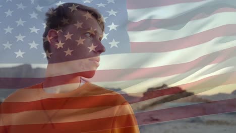 animation of waving flag of america over caucasian young man relaxing at beach during sunset