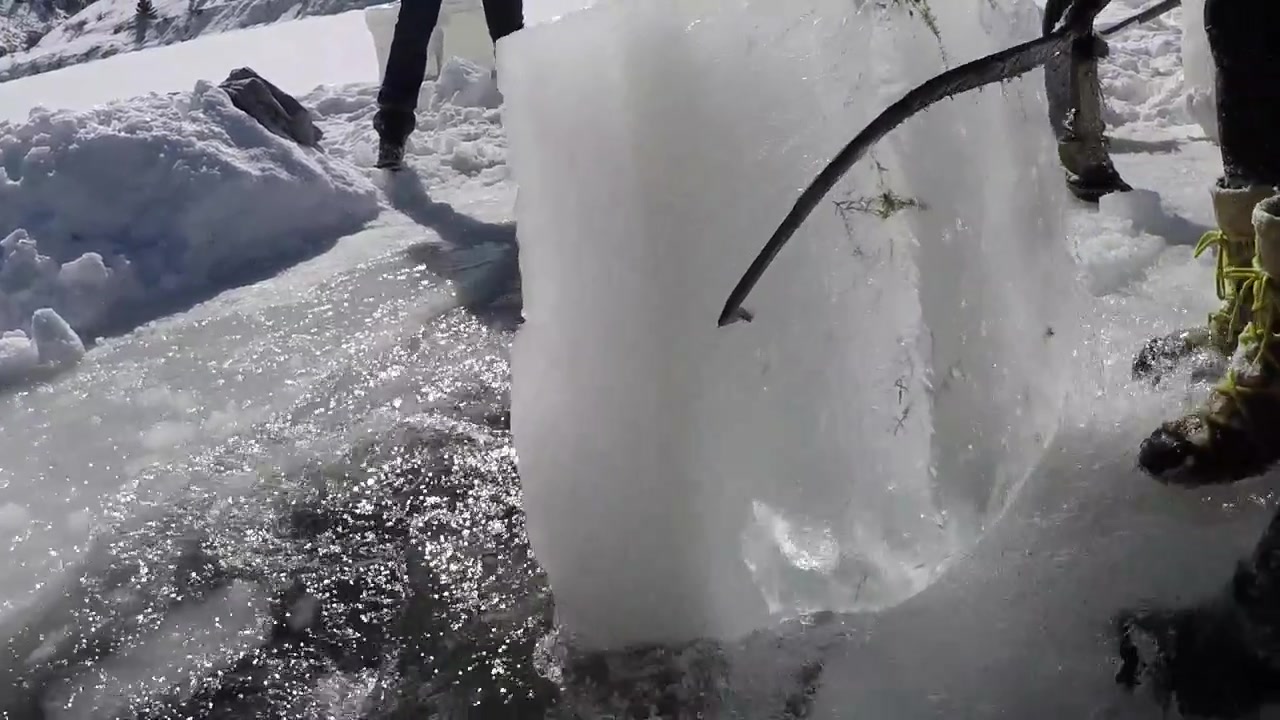 Bloque de hielo sacado de un lago en cámara lenta usando pinzas de horquilla