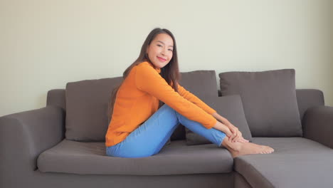 웃는 여자는 소파에 편안 하 고 카메라에 보이는