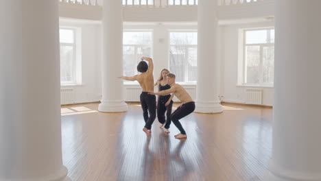 tres bailarines contemporáneos profesionales entrenando movimientos de baile en coreografía en el estudio