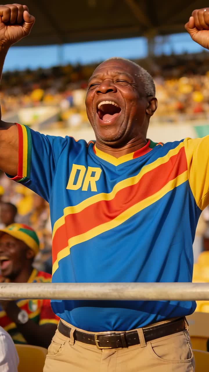 Video verticale: Anziano che esulta alzando i pugni, urlando con una maglia della DR verso gli spalti che reagiscono a un gol