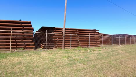 POV-driving-past-large-stockpiles-of-metal-panels-for-building-the-border-wall-between-Texas-and-Mexico