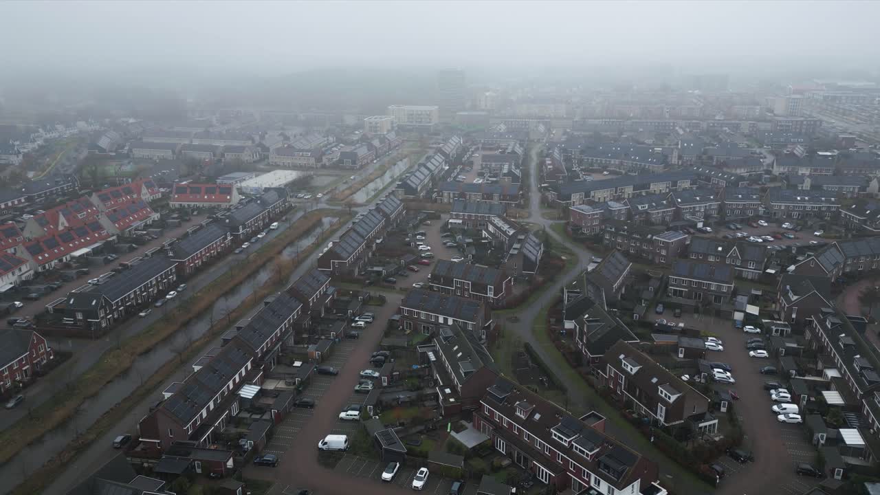 Drone-luchtfoto van een buitenwijk in Rijswijk, Nederland, met woonblokken, straten, geparkeerde auto's en ochtendmist