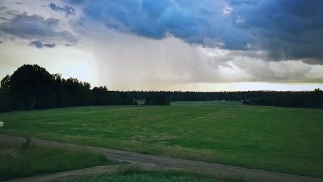 flying over green fields with cloudy sky near hjo, sweden - aerial drone shot