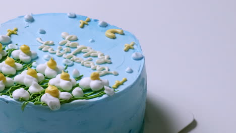 panning the camera from right to left on a blue, frosted sponge cake for a birthday celebration