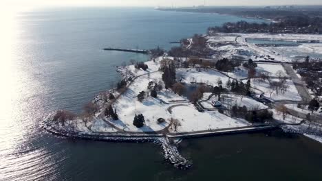 drone circling around snowy lakeshore park on lake ontario in mississauga