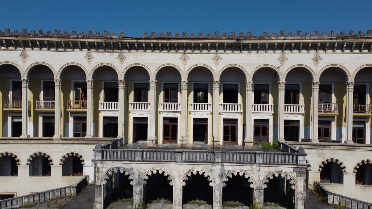 Exterior of grand abandoned spa building in Tskaltubo with tall columns and faded details