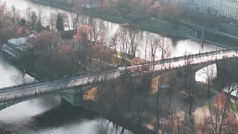 aerial follow of city public transportation tram cross river on bridge