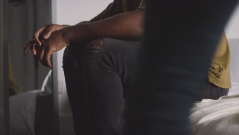 close up of loving couple relaxing at home sitting on bed at night talking together 2