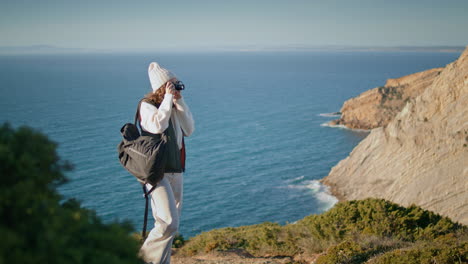 mountain woman making photo on hiking trip vertical. girl tourist admire ocean