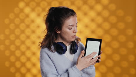 woman doing promotion for reading tablet, showing features, studio background