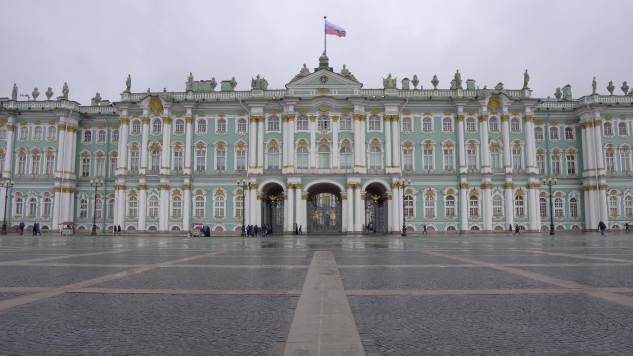 Static shot of winter palace from palace square with russian flag waiving in the middle, st. petersbrug, russia