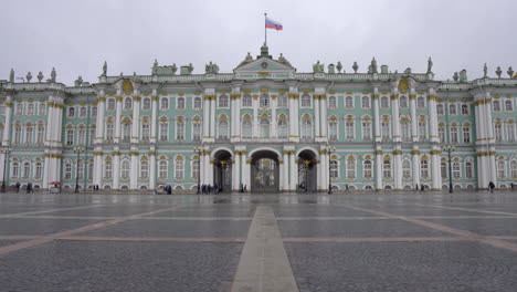 static shot of winter palace from palace square with russian flag waiving in the middle, st. petersbrug, russia