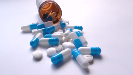assorted pills and capsules on white background