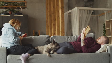 Couple-Lying-On-The-Couch-With-Their-Bulldog