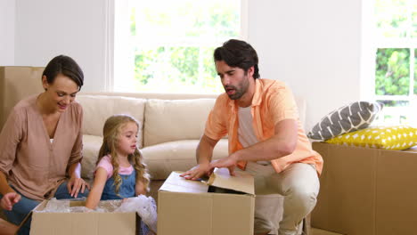 Familia-Abriendo-Caja-De-Cartón-