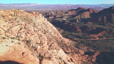 beautiful aerial reverse reveal of orange mountains and a green valley in yant flats, utah near st