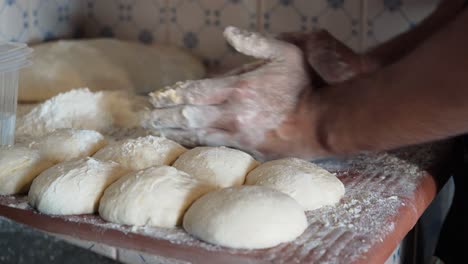 baker shaping bread loaf dough with flour in hands