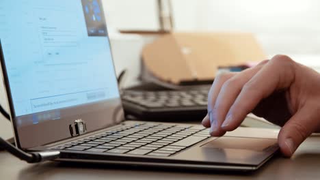 manos del hombre escribiendo en un teclado de computadora portátil