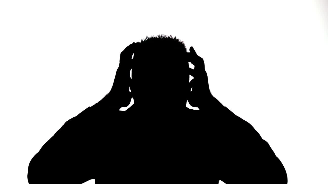 스트레스를 받는 사업가 의 실루 이 머리 에 손 을 고 있다