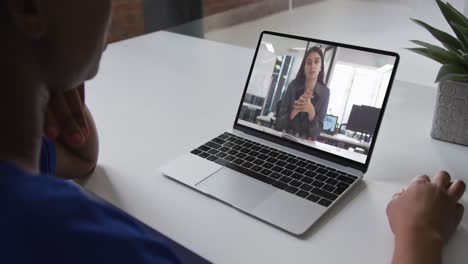 African-american-woman-talking-on-video-call-on-laptop-with-female-office-colleague-at-home