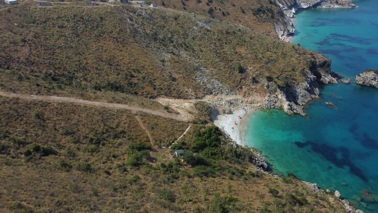 Ripresa drone di una spiaggia solitaria sul Mediterraneo, il drone si allontana da una spiaggia vicino a Ksamil, Albania, rivelando il paesaggio.
