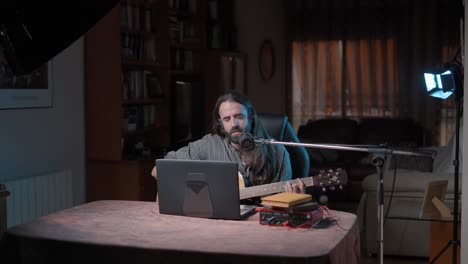 Man Singing and Playing Acoustic Guitar at Home