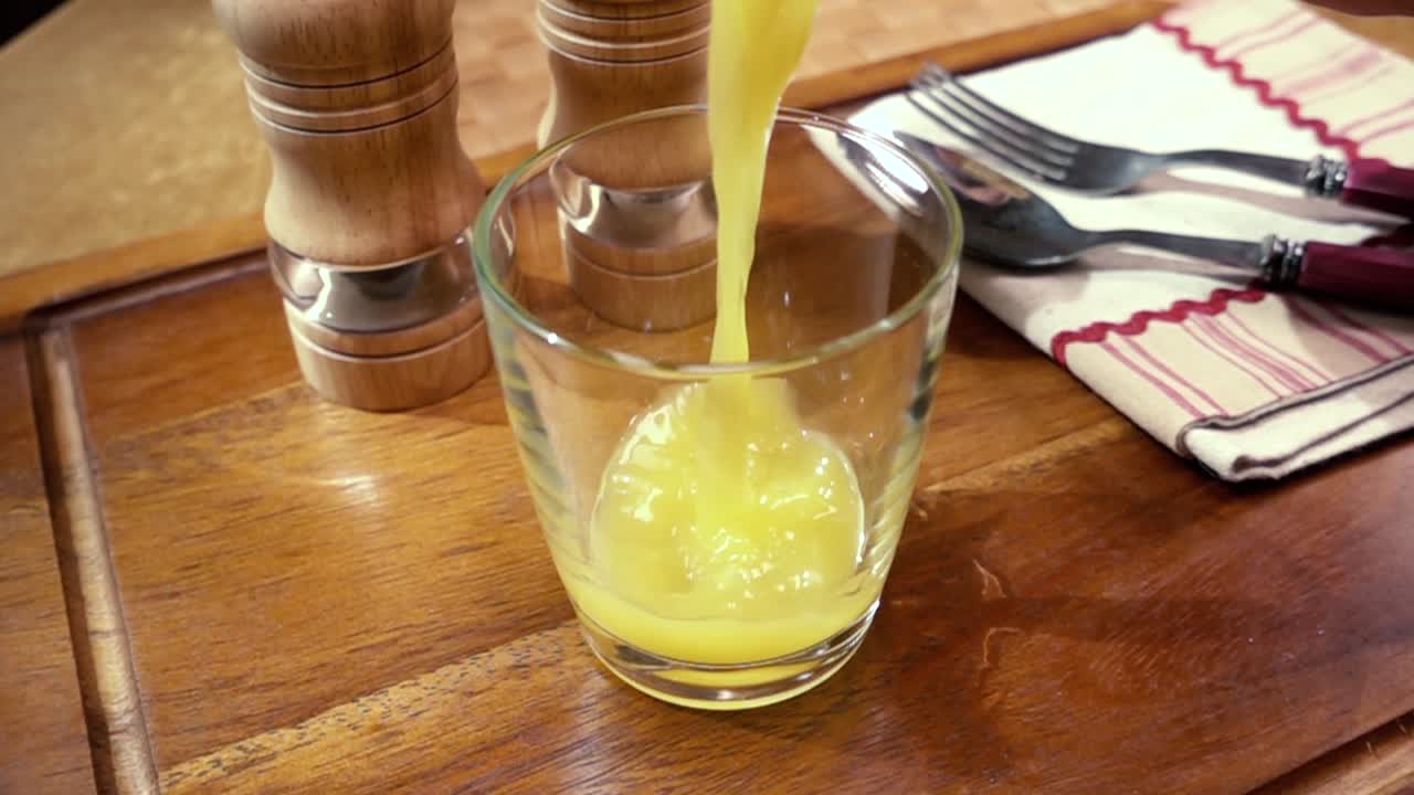 오렌지 주스가 잔에  ⁇ 어지는 것, 아침 아침 식사, 회전 추적 촬영과 함께 느린 동작.