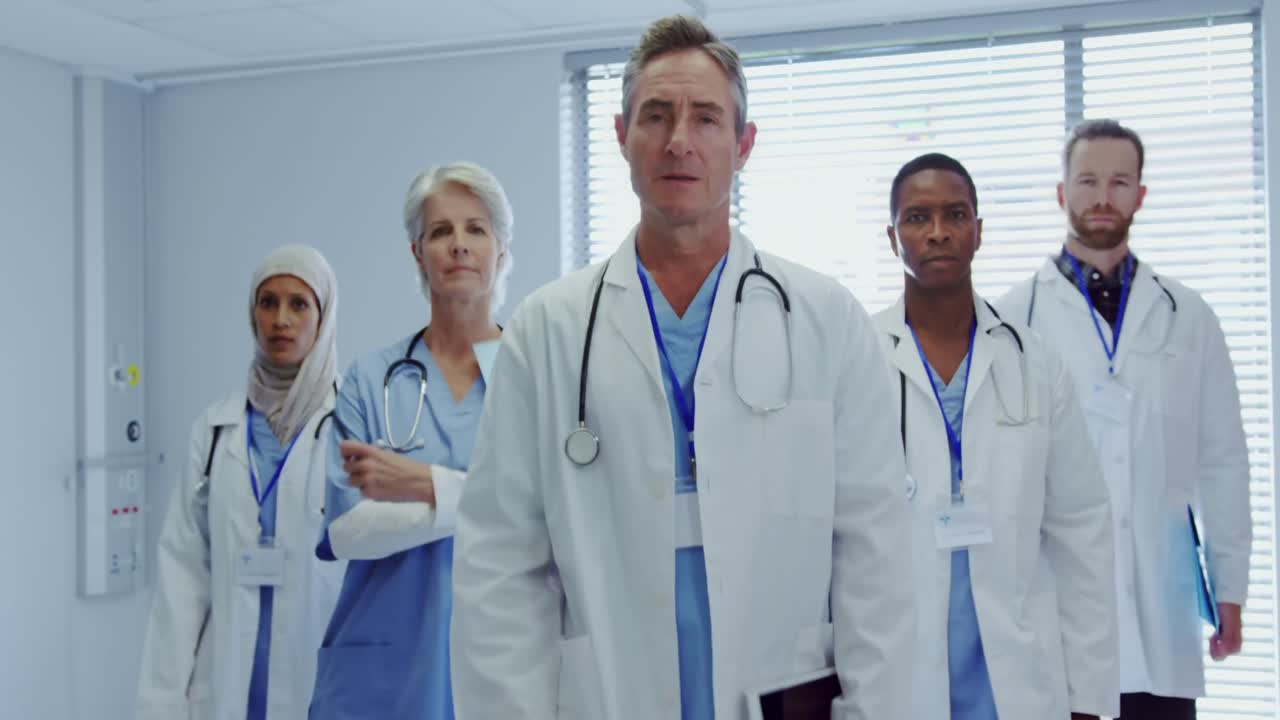 Front view of Multi-ethnic doctors standing together with arms crossed at hospital