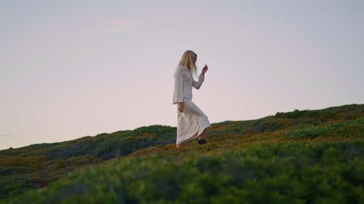 kleidung dame klettern natur am abend vertikal. attraktives mädchen spaziergang hügel sonnenuntergang