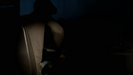 person working on computer in a dark room at night