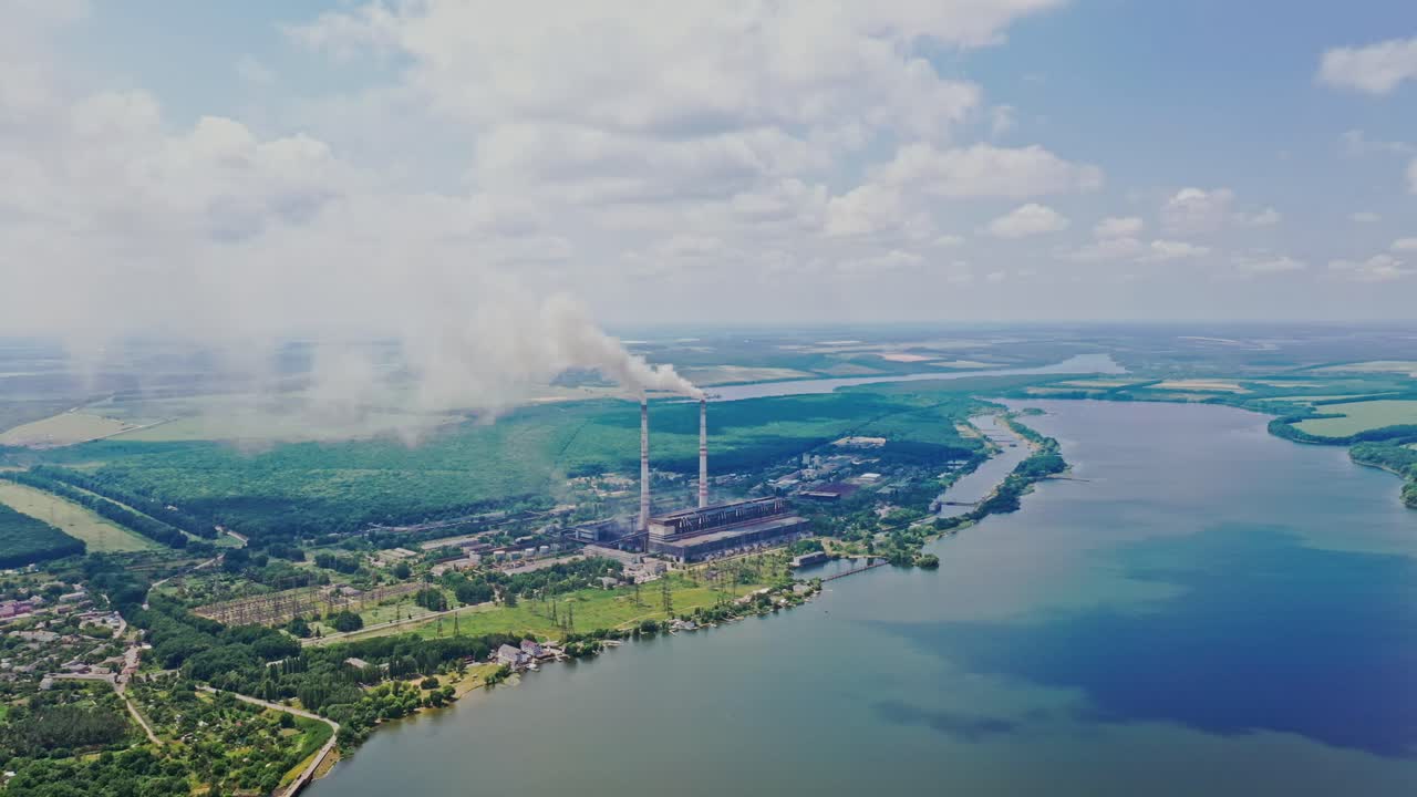 Poor environment in the countryside with huge factory. Harmful emissions from pipes into the environment. Natural scenery and metallurgy plant. Aerial view.