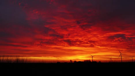 Aerogeneradores-De-Parques-Eólicos-Timelapse-Durante-Un-Espectacular-Paisaje-De-Cielo-Rojo-Y-Naranja-Mientras-Generan-Energía-Eólica