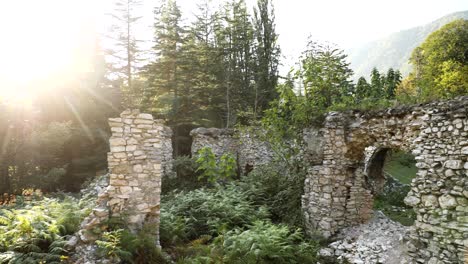 zeda-gordi, georgia. remains of palace of princes of 18 century in park dadiani in canyon okatse in sunset or sunrise time. sun sunshine with natural sunlight and sun rays through trees