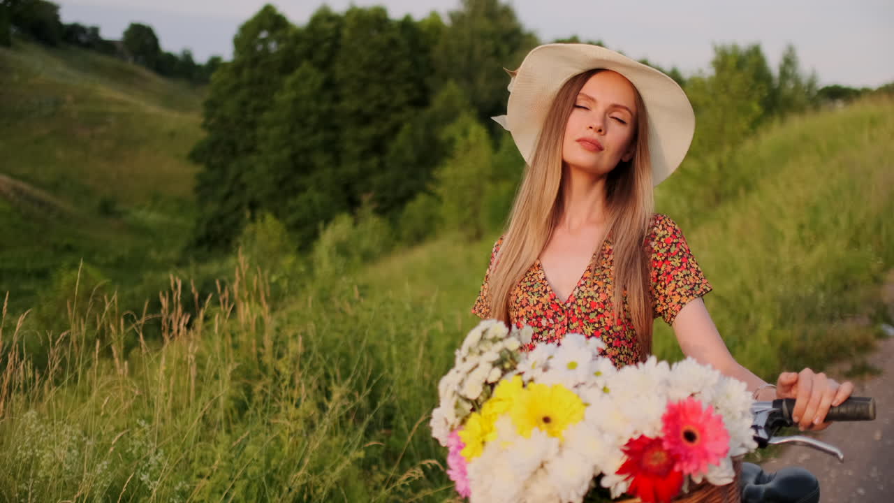chica de plan medio en vestido va con bicicleta y flores en el campo