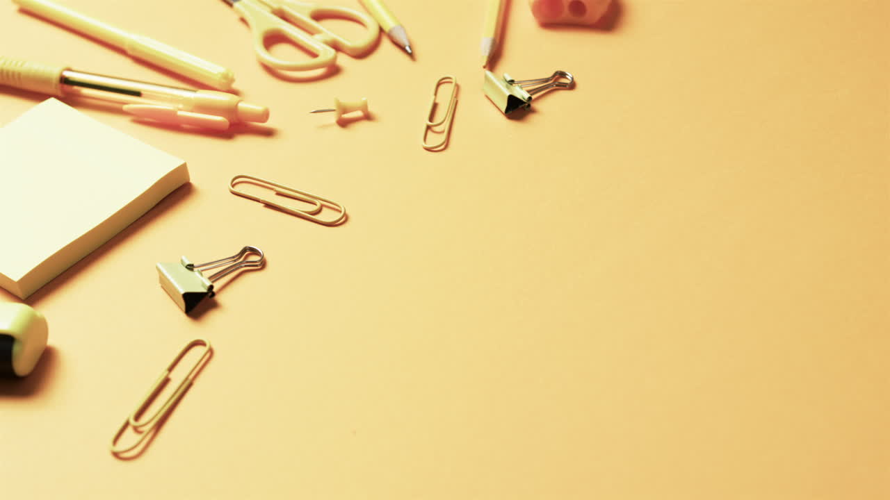 close up de papelería escolar con espacio de copia en fondo naranja, en cámara lenta