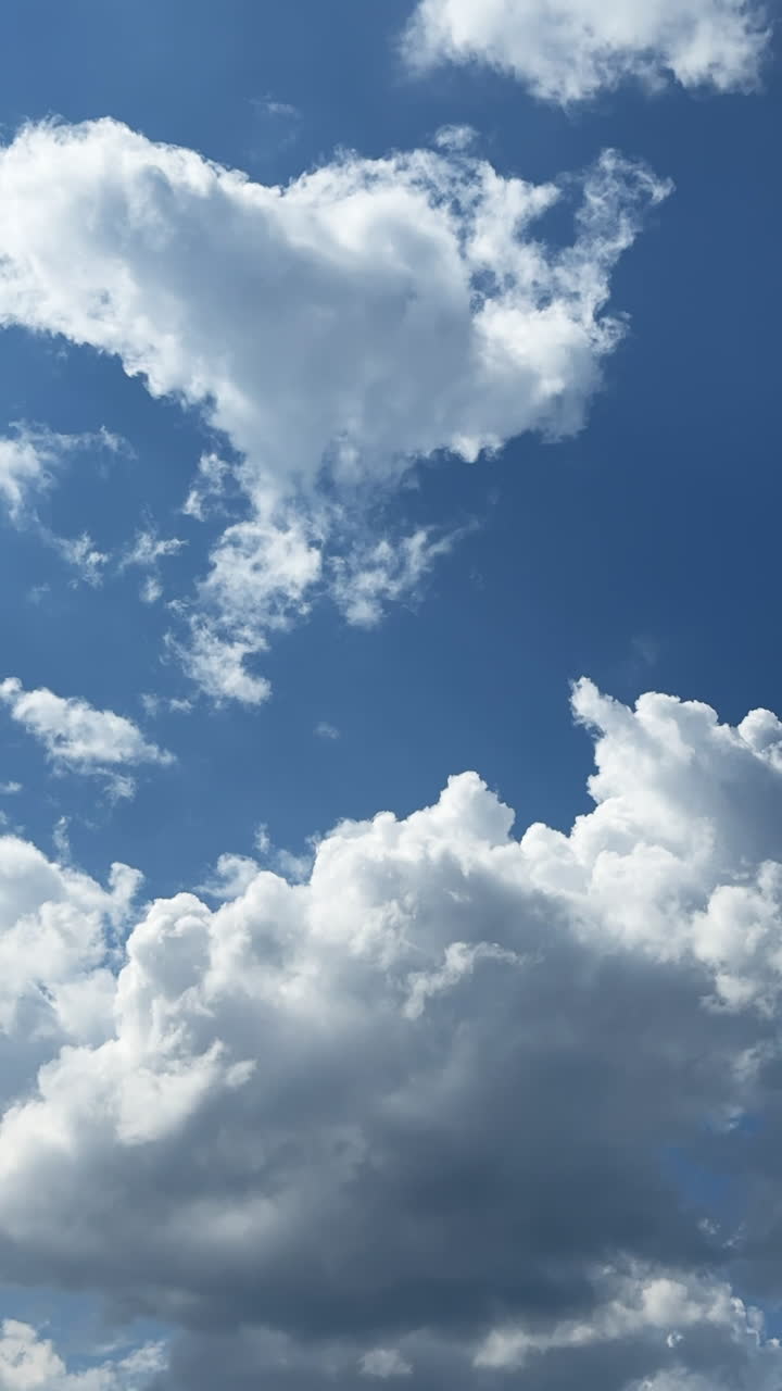 Little soft clouds grow big. Transformation of cloudscape in the blue sky. Timelapse. Vertical video.