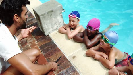 coach giving swimming lesson to his students