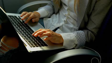 Woman-using-mobile-phone-while-working-on-laptop-in-the-ferry-4k